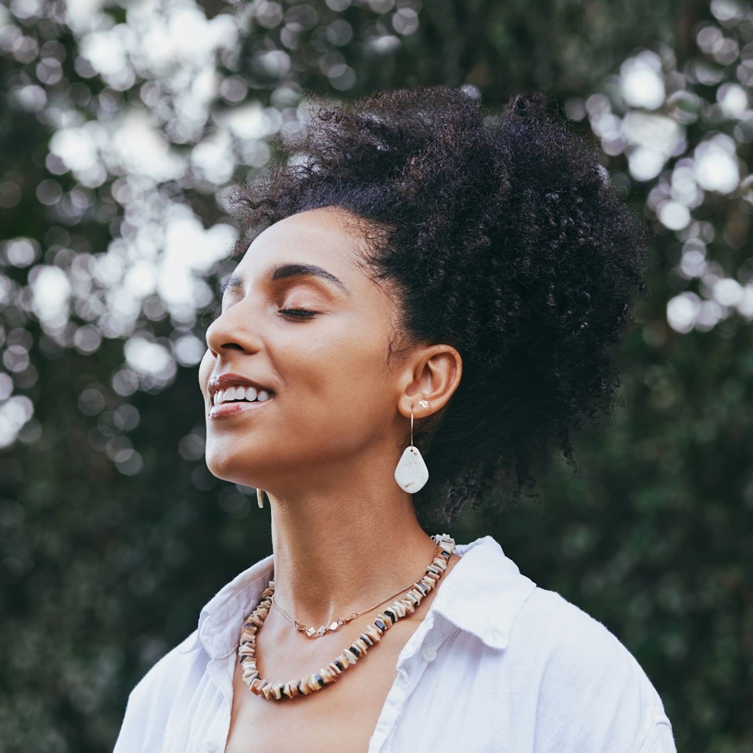 Frau meditiert draußen im Park mit geschlossenen Augen