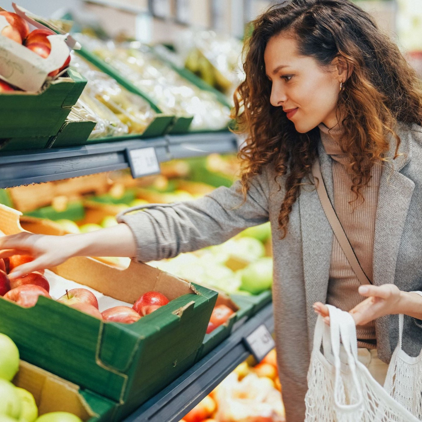 Frau kauft Äpfel im Supermarkt