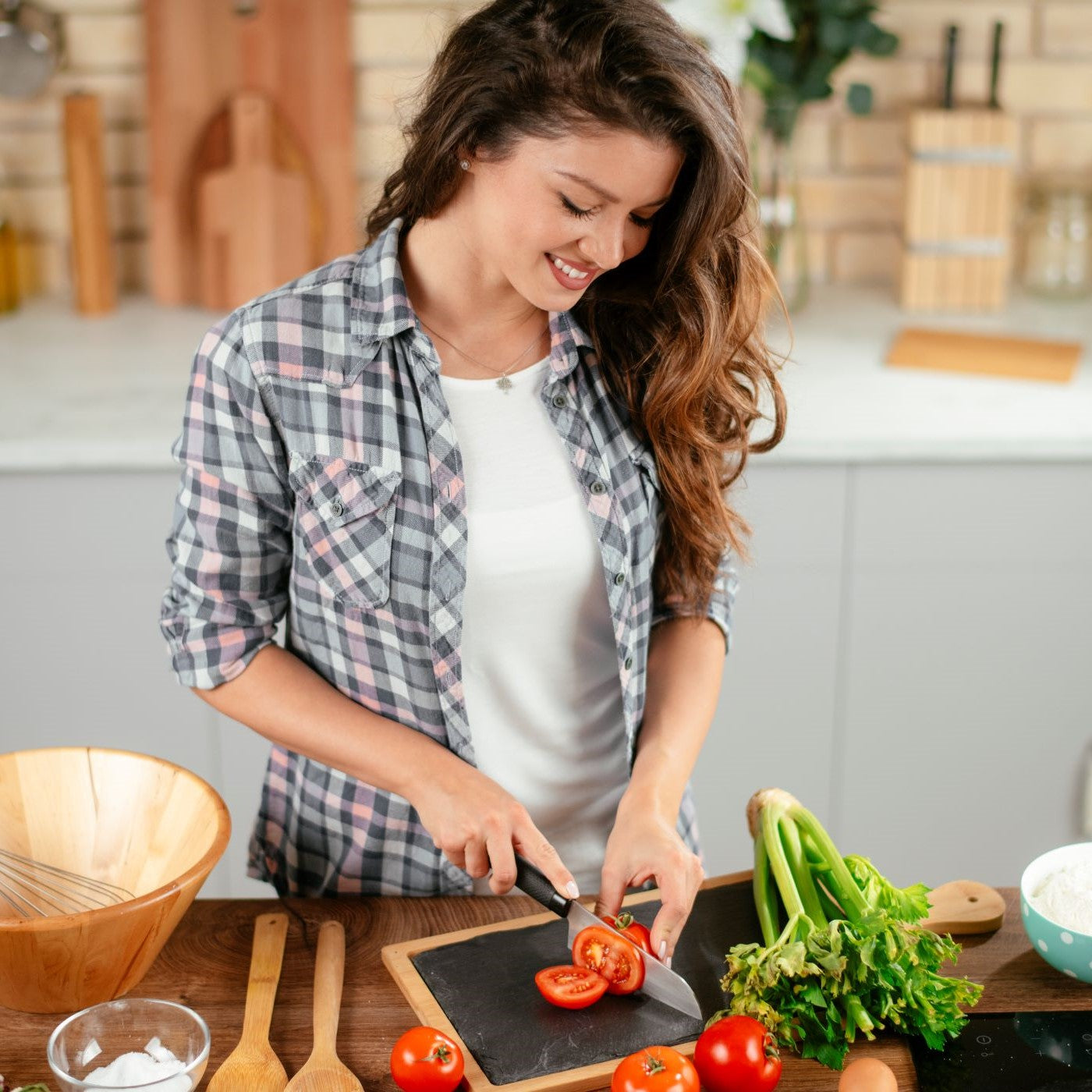 Frau schneidet Tomaten in der Küche