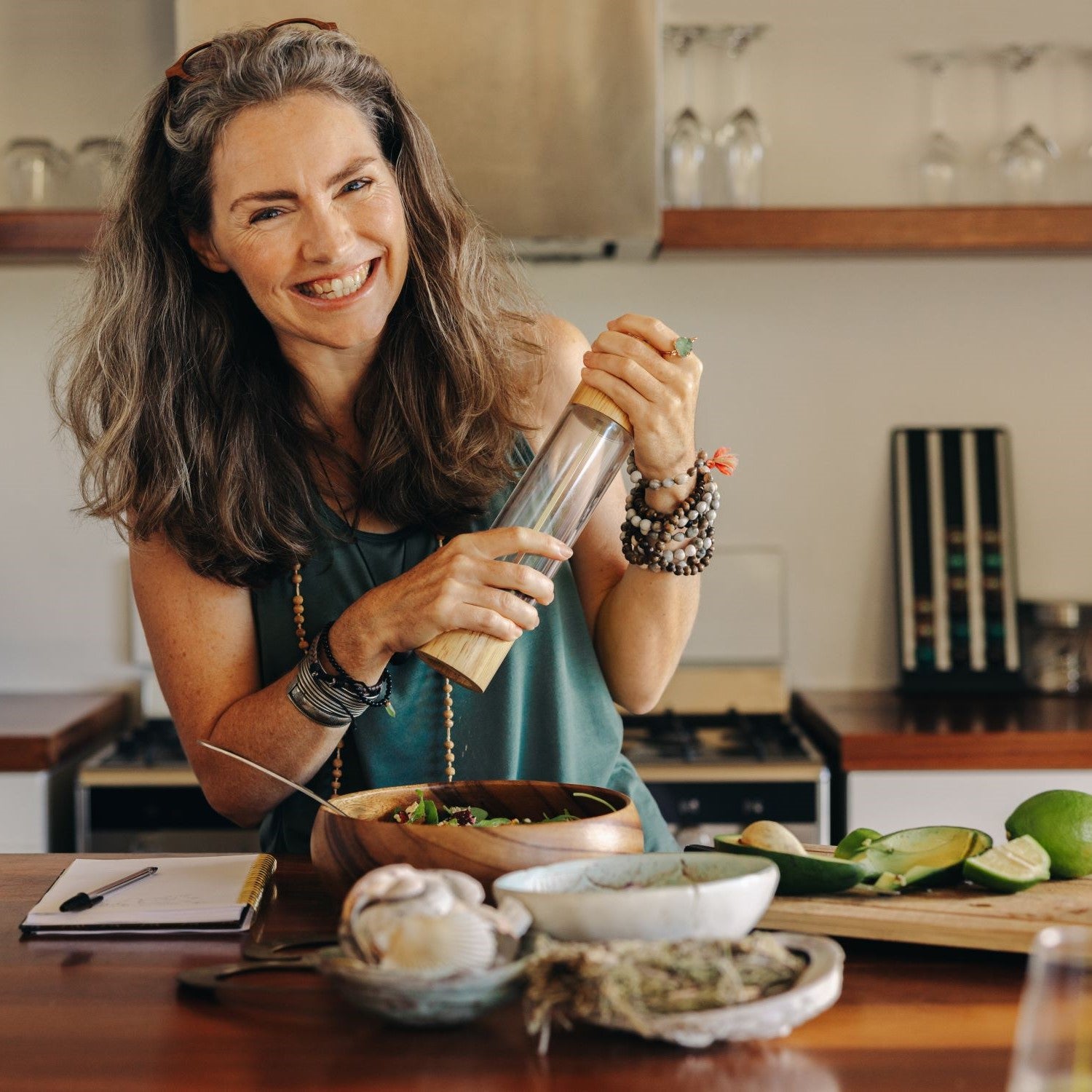 Frau würzt ein basisches Gericht mit Pfeffer