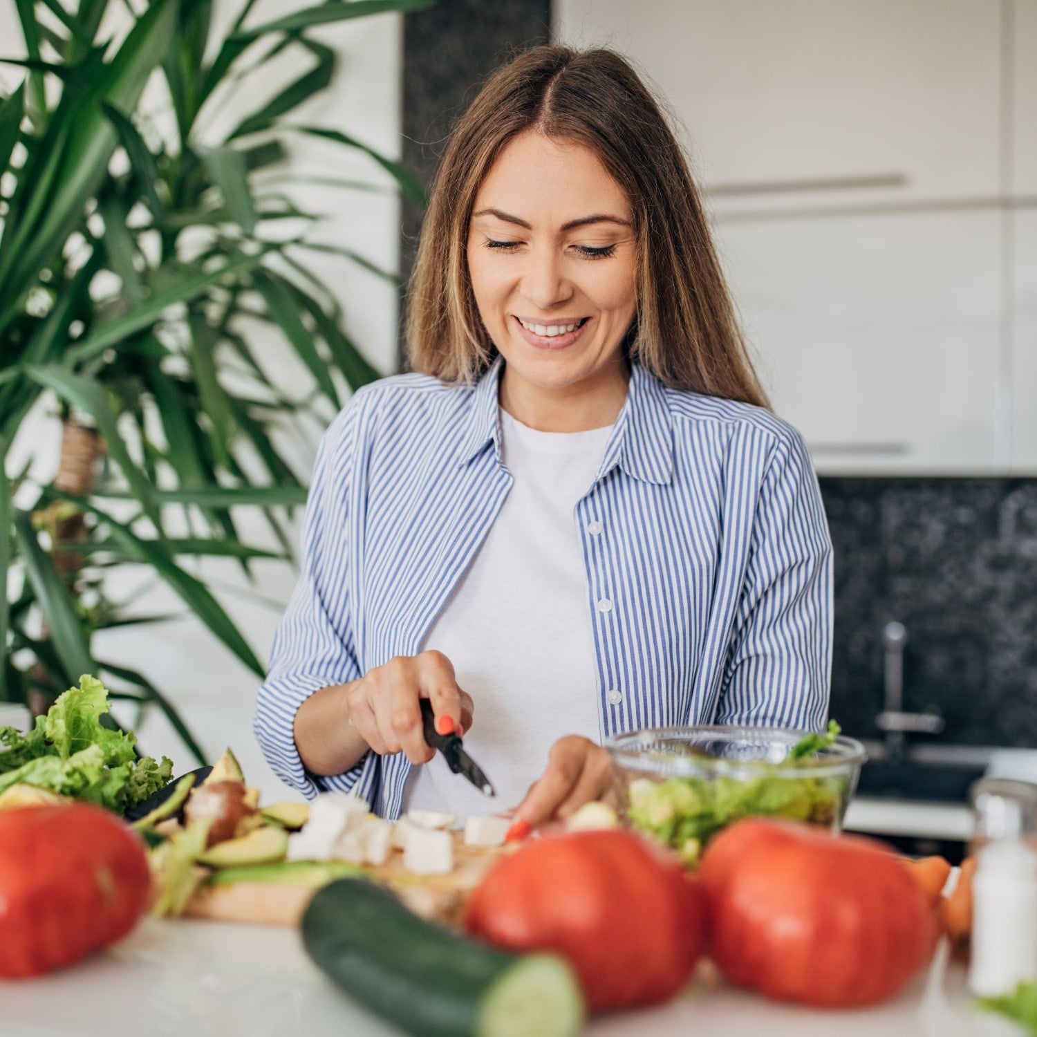 Frau schneidet Gemüse in der Küche