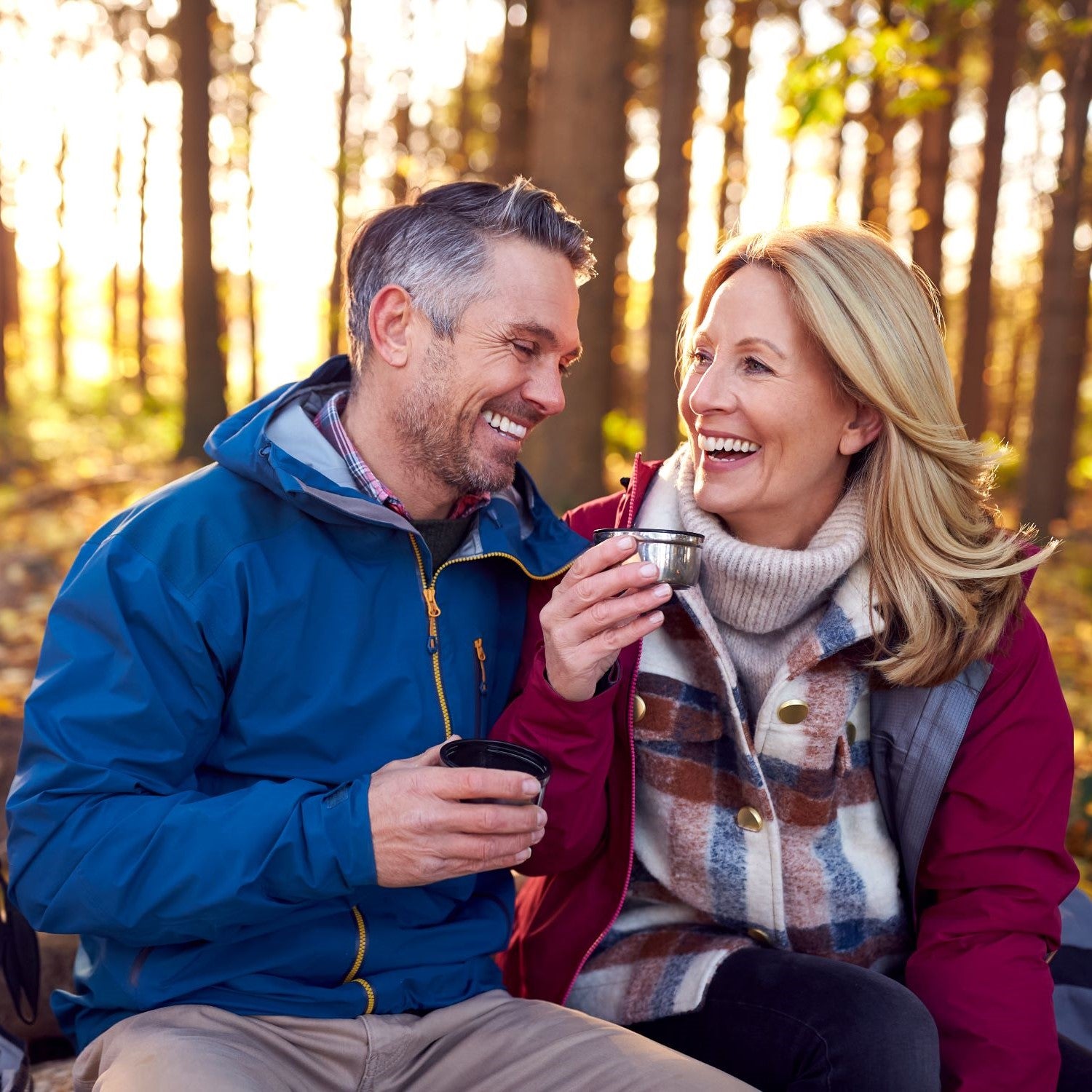 Pärchen macht eine Pause im Wald und trinkt aus einer Thermoskanne