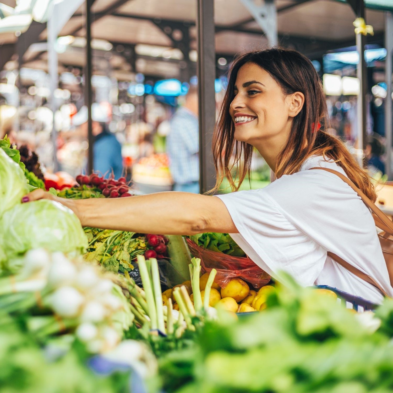 Frau kauft Kohlgemüse auf dem Wochenmarkt