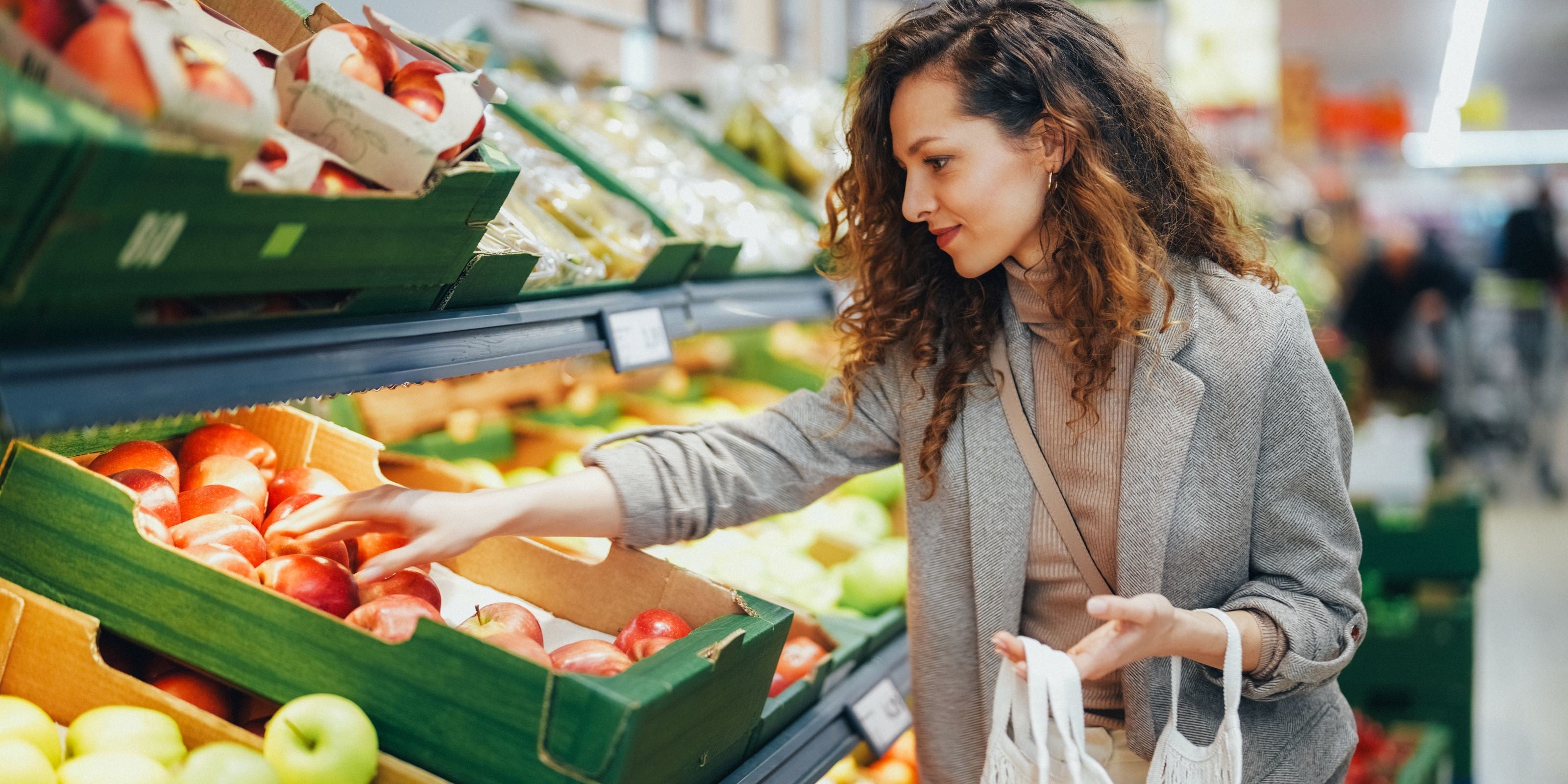 Frau kauft Äpfel im Supermarkt
