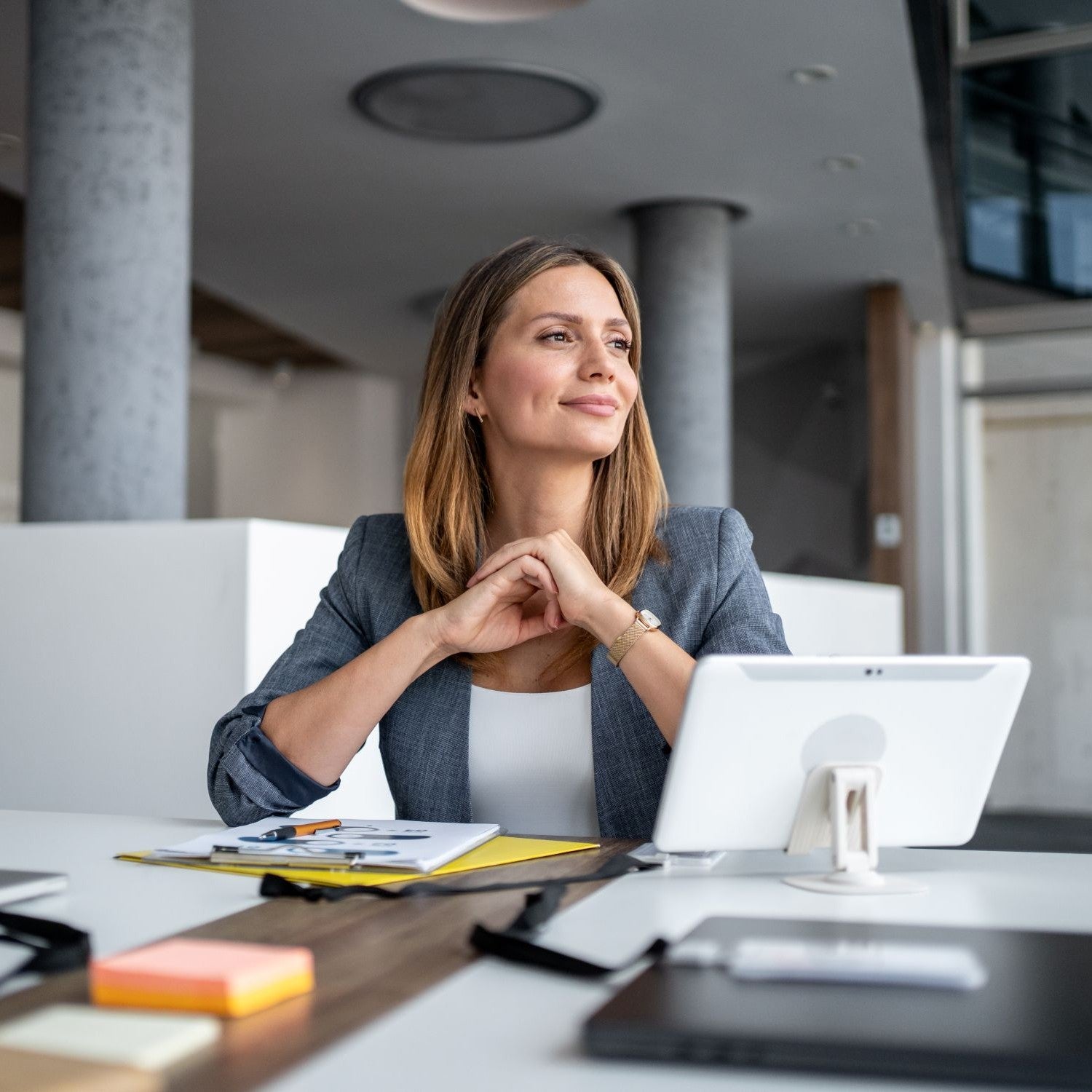 Frau sitzt am Schreibtisch und denkt nach