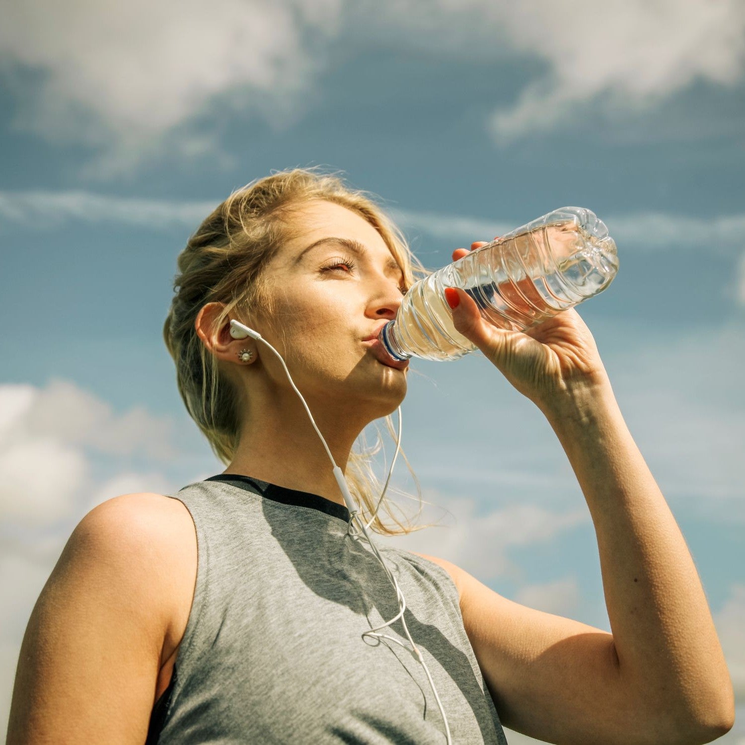 Sportlerin trinkt Wasser aus einer Flasche