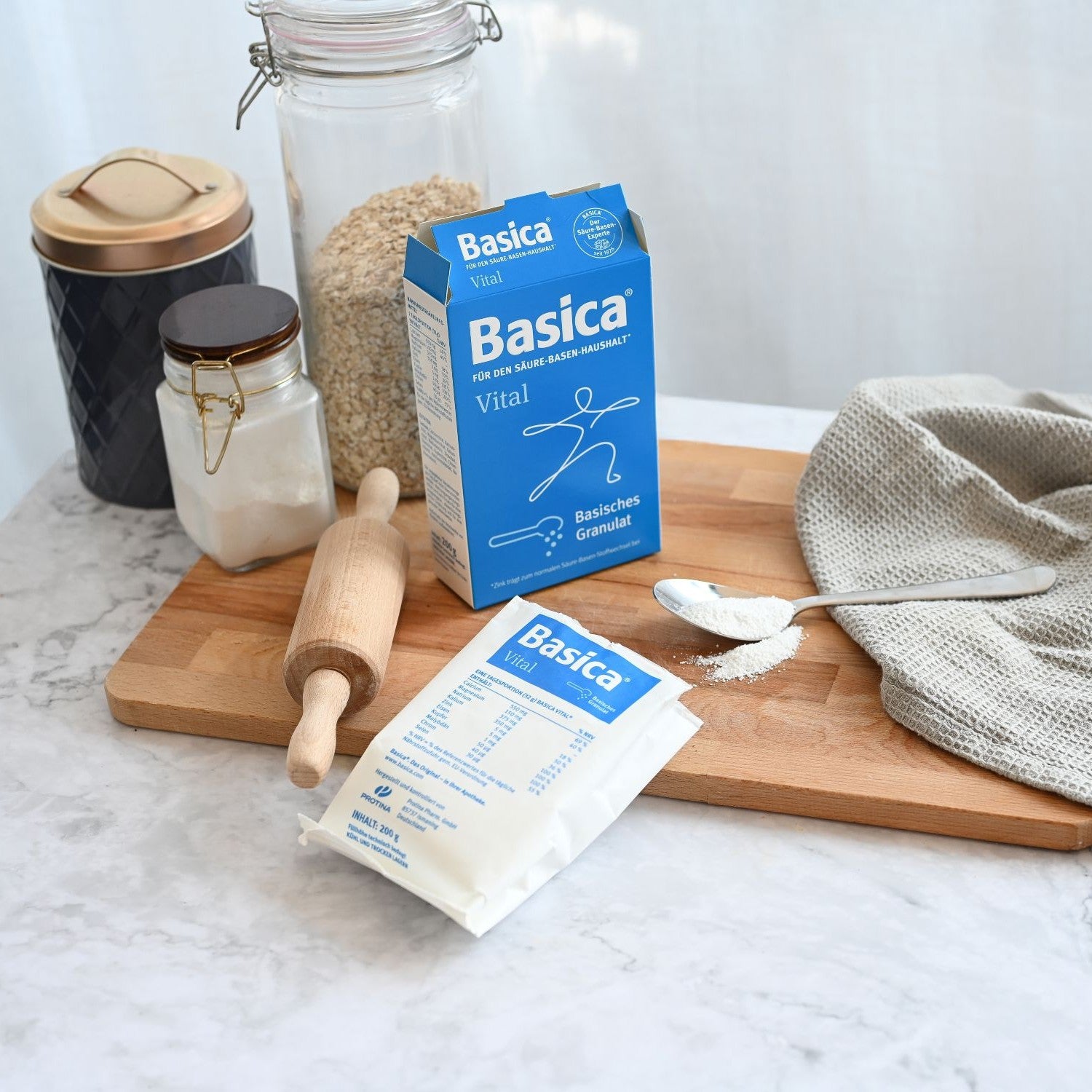 Basica Vital neben einem Teigroller und einem Glas Haferflocken