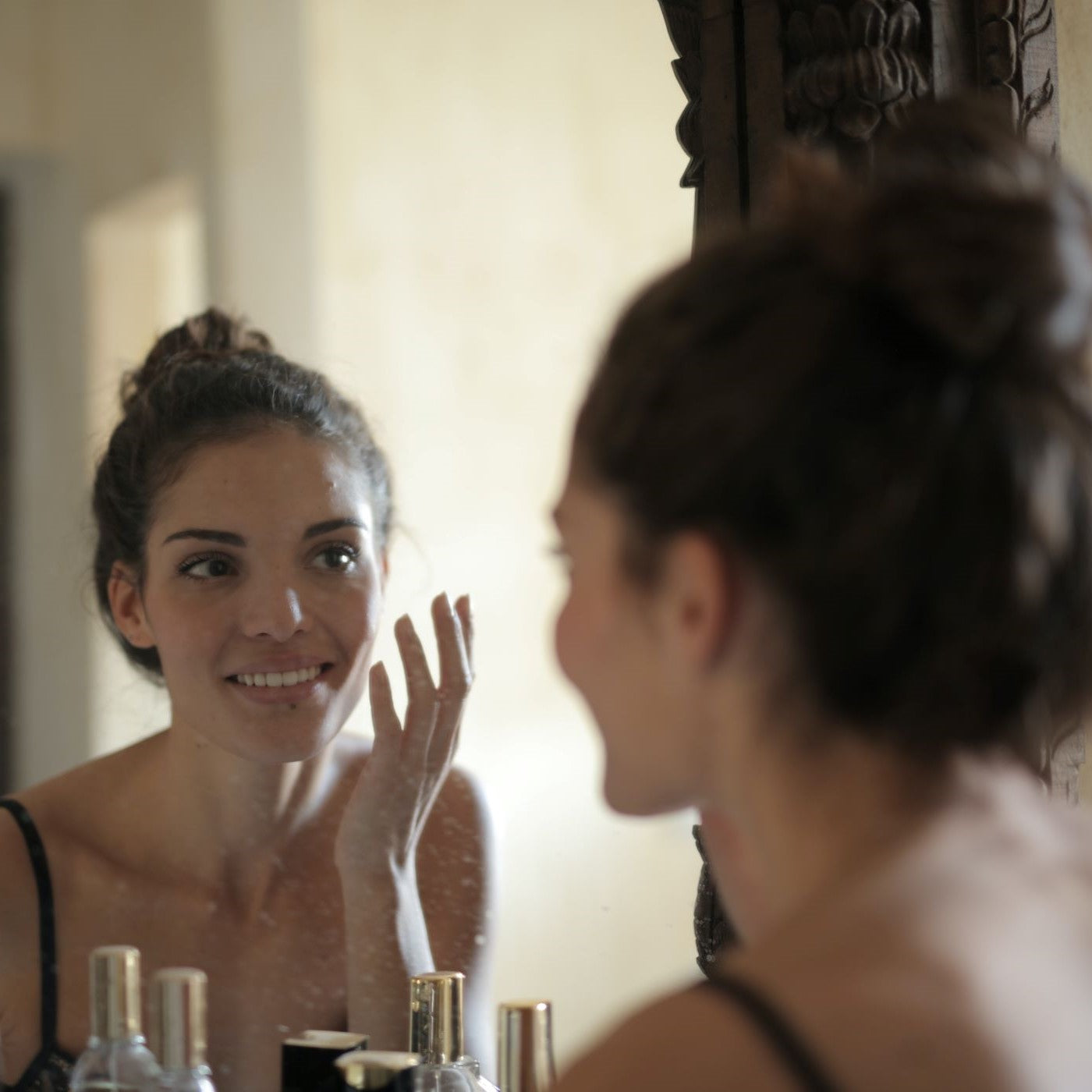 Frau betrachtet sich im Spiegel