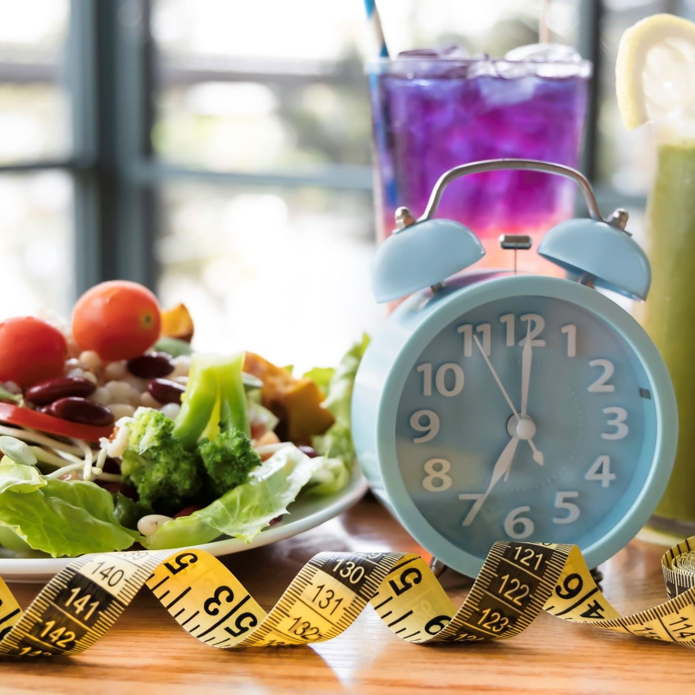 Intervallfasten symbolisiert durch einen Salatteller, ein Maßband und eine Uhr