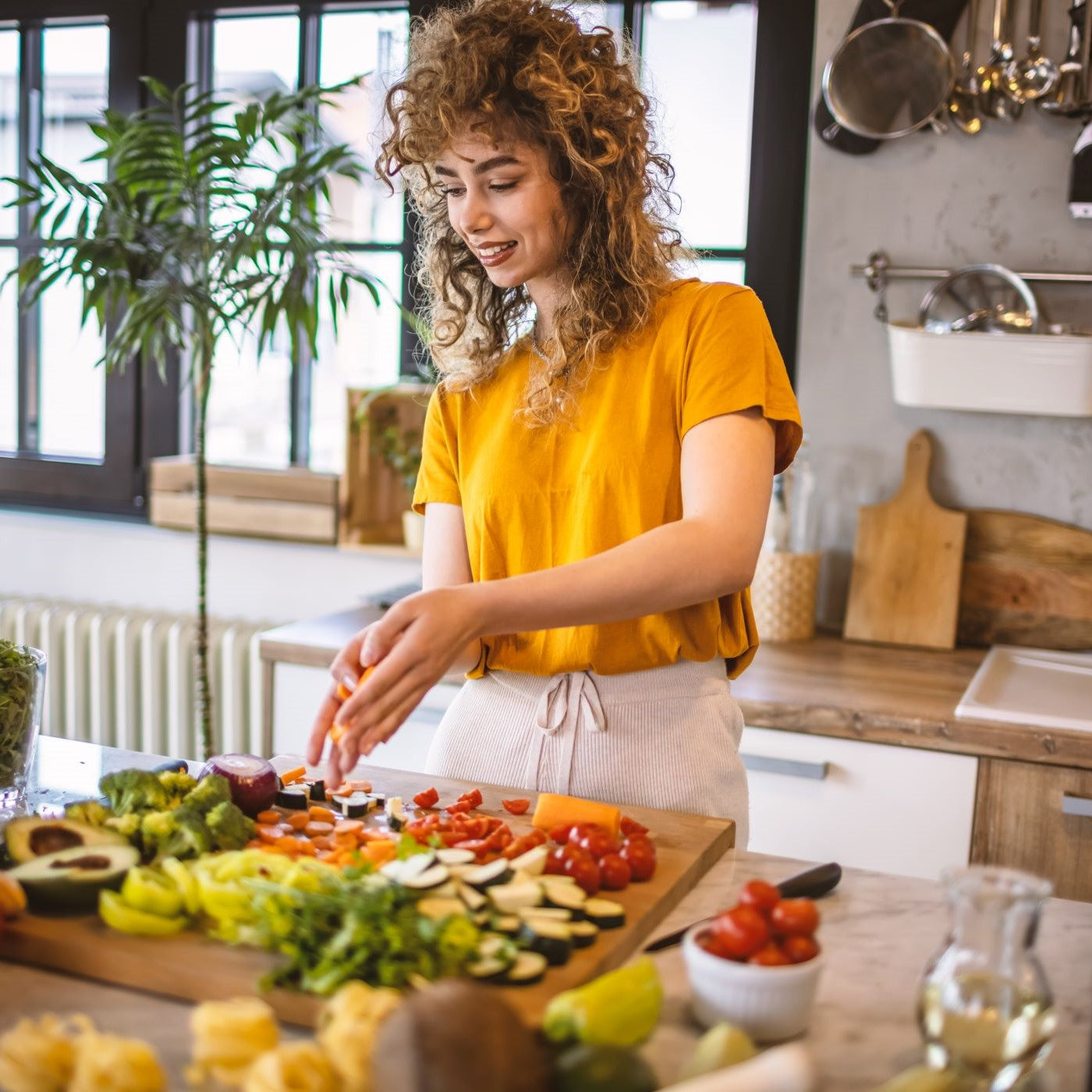 Frau schneidet verschiedene Gemüsesorten in der Küche