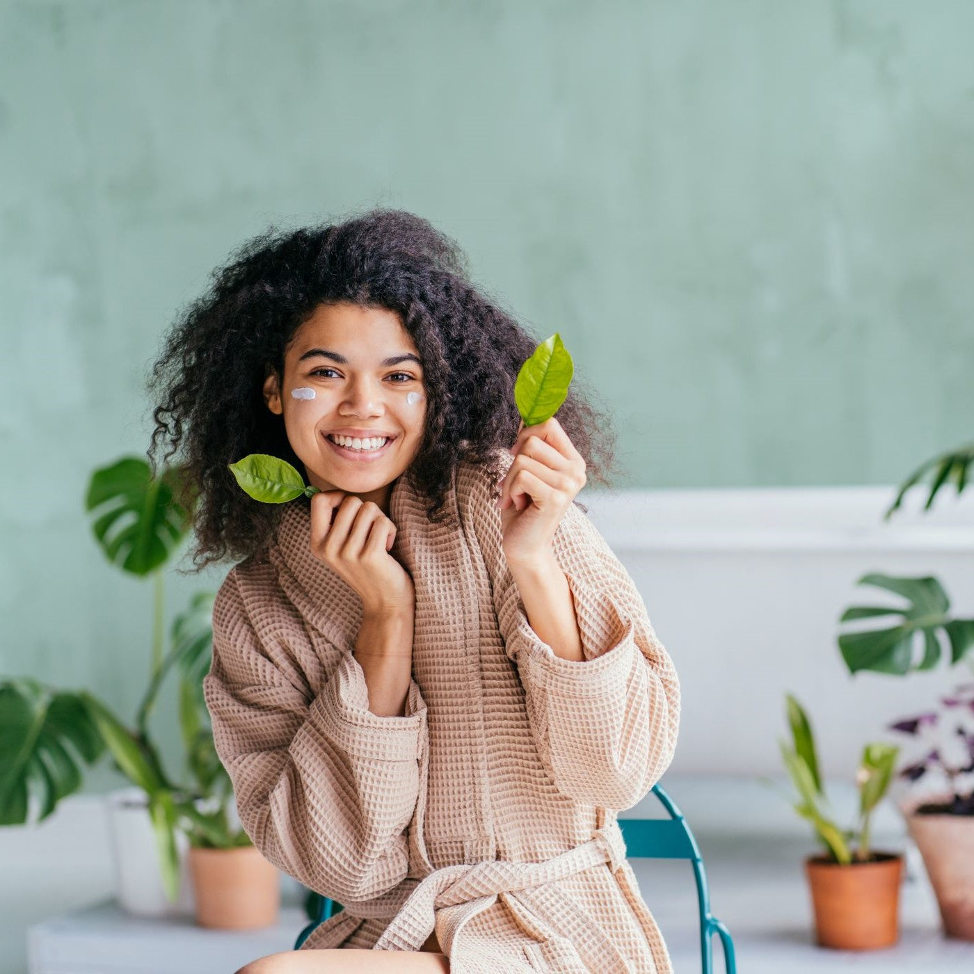 Frau im Bademantel führt ihre Pflegeroutine durch