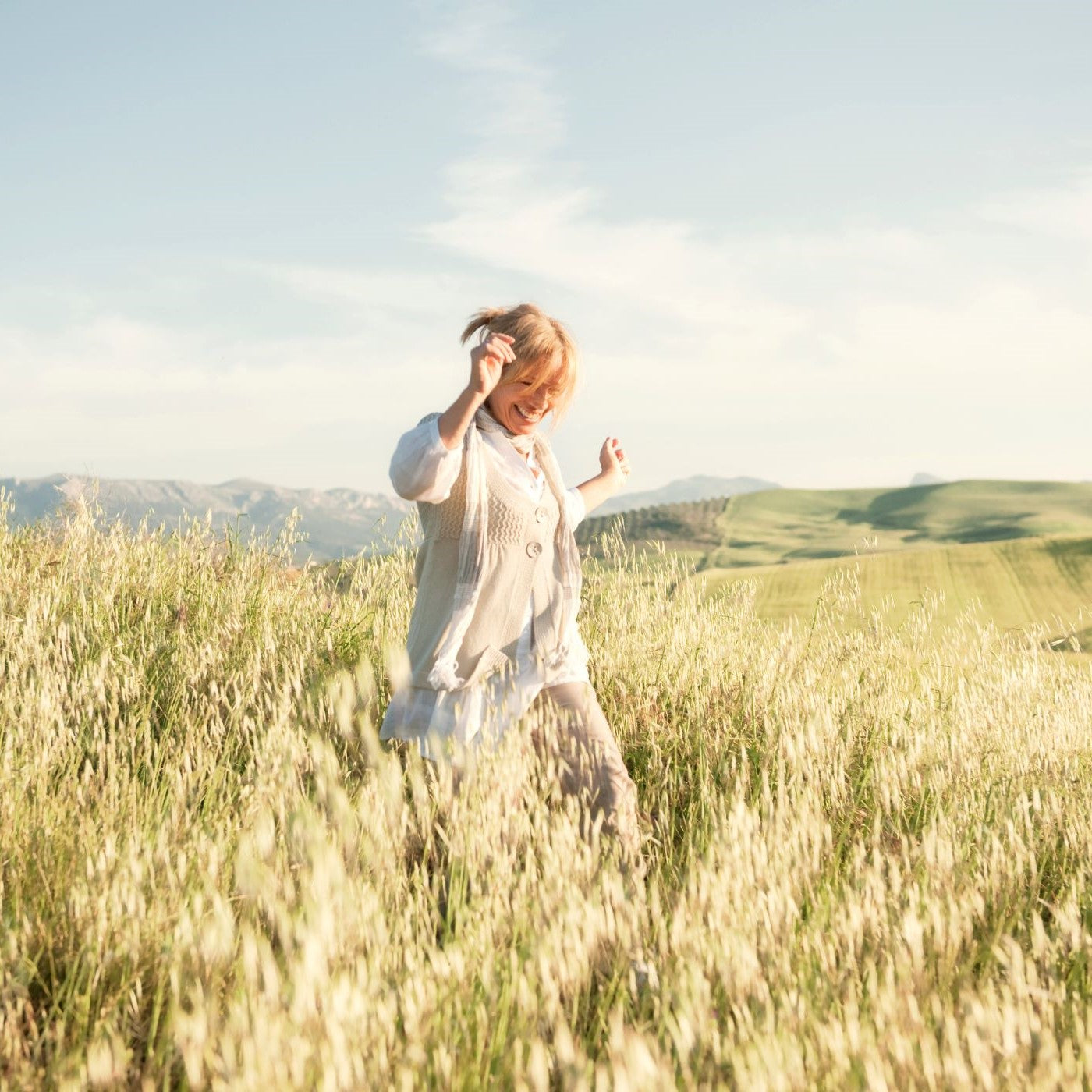 Frau geht durch ein Weizenfeld